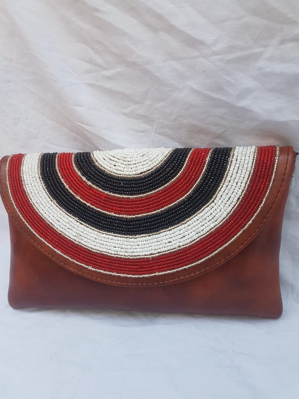 Leather clutch purse decorated with colorful beads.