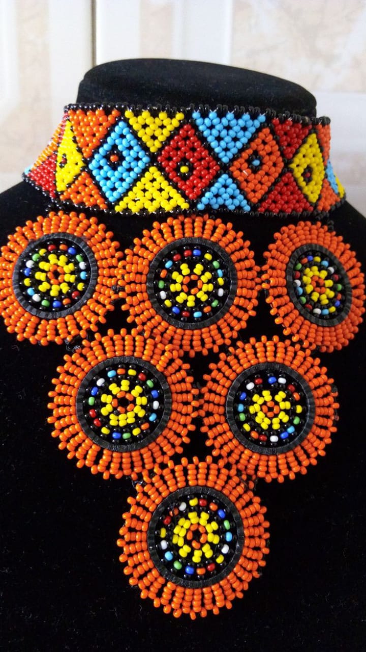 Multicolor choker beaded necklace with orange pendants.