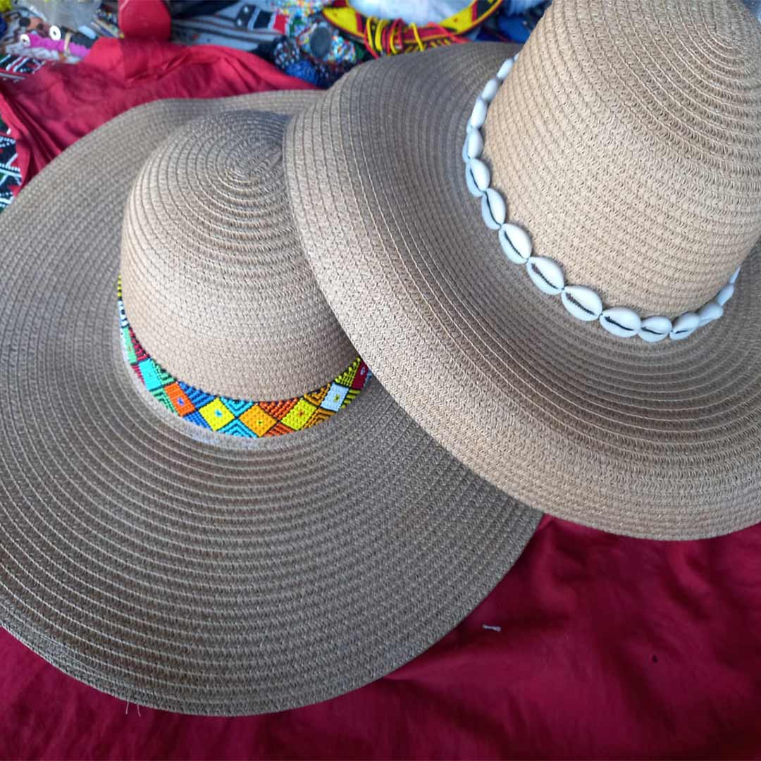 2 woven hats decorated with colorful beads and shells
